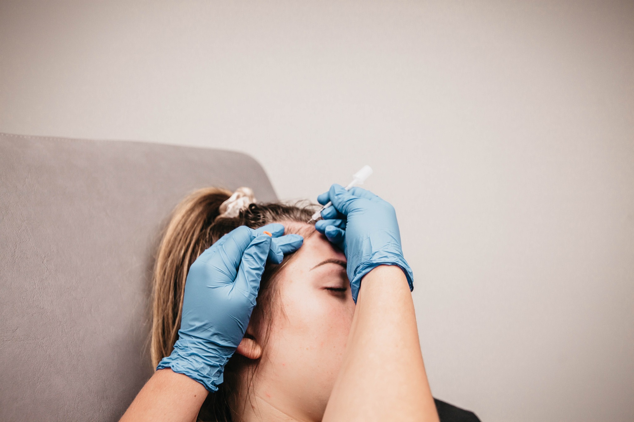 An image of a woman undergoing Hair Loss Treatment by a doctor