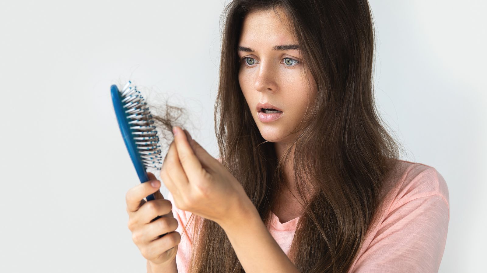 Woman holding a comb and worried.