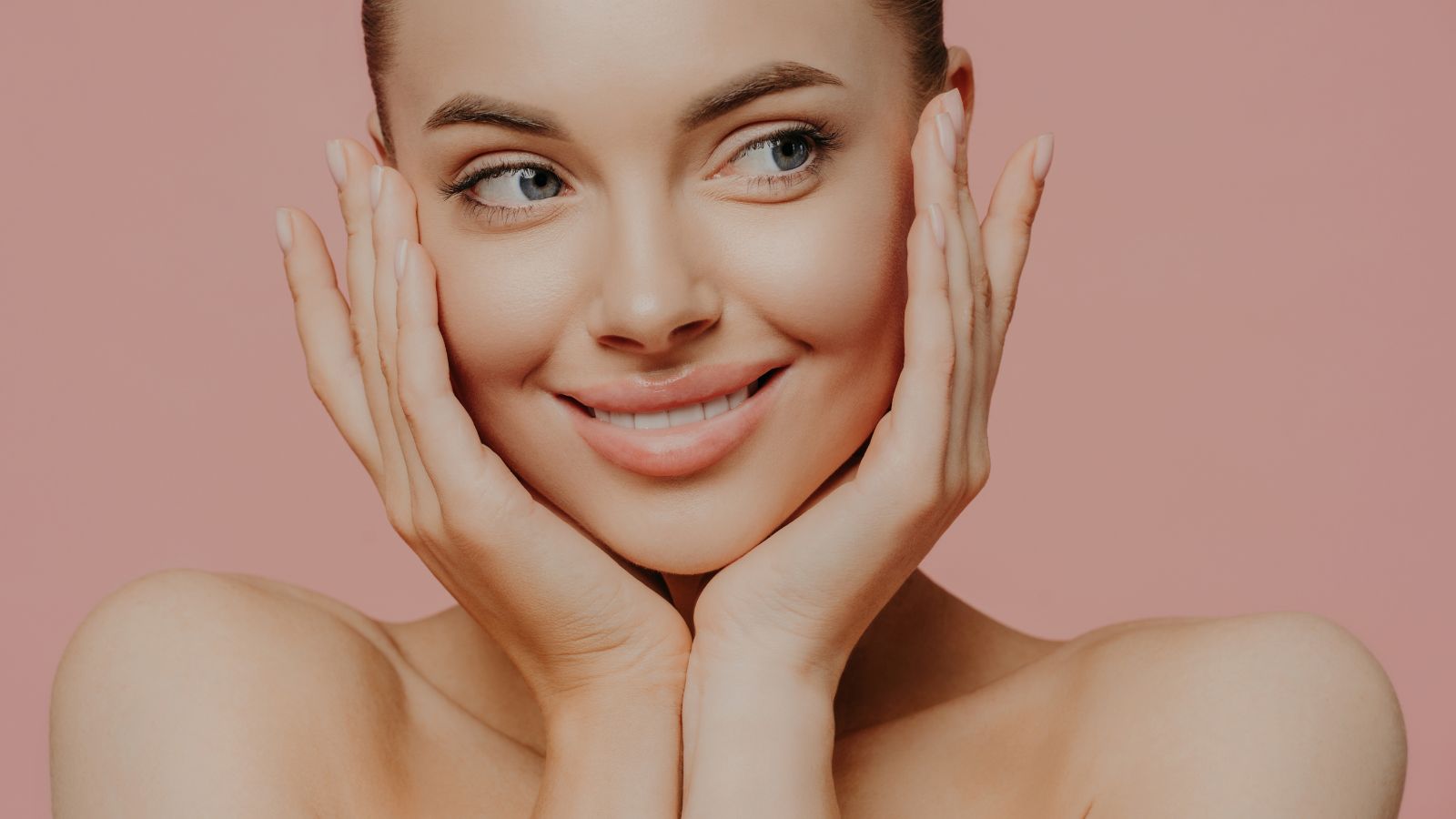 Woman holding both her cheeks while smiling. - Vampire Facelift Face